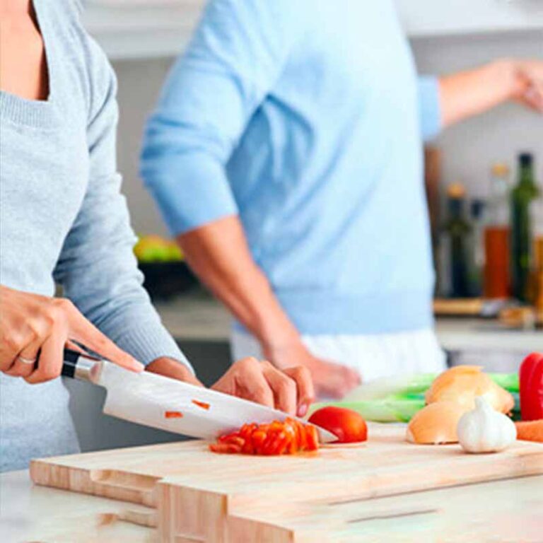 Couple using culinary medicine coaching chopping tomatoes